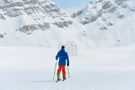 Un esquiador solitario se enfrenta a los elementos en una peligrosa subida a la cima de un pico alpino.