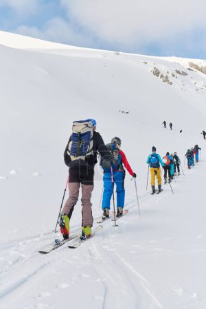 Foto de Un grupo de esquiadores profesionales asciende a un peligroso pico nevado utilizando equipos de última generación. - Imagen libre de derechos
