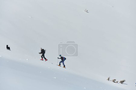 Téléchargez les photos : Un groupe d'alpinistes professionnels gravit un pic enneigé dangereux à l'aide d'équipements de pointe. - en image libre de droit