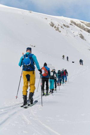 Un grupo de esquiadores profesionales asciende a un peligroso pico nevado utilizando equipos de última generación. 
