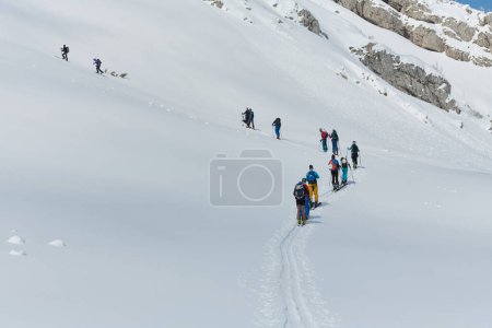 Photo for A group of professional ski mountaineers ascend a dangerous snowy peak using state-of-the-art equipment. - Royalty Free Image