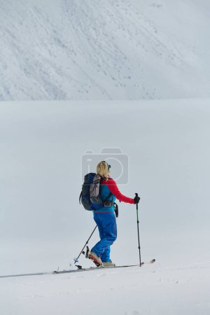 Photo for A determined skier scales a snow-capped peak in the Alps, carrying backcountry gear for an epic descent - Royalty Free Image