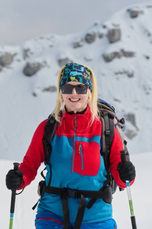Photo for A professional woman skier rejoices after successfully climbing the snowy peaks of the Alps. - Royalty Free Image