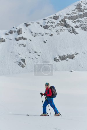 Foto de Una esquiadora profesional se regocija tras escalar con éxito los picos nevados de los Alpes. - Imagen libre de derechos