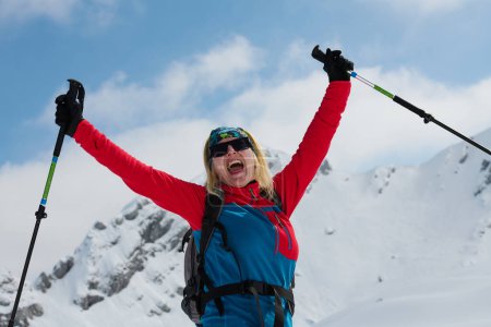 Photo for A professional woman skier rejoices after successfully climbing the snowy peaks of the Alps. - Royalty Free Image