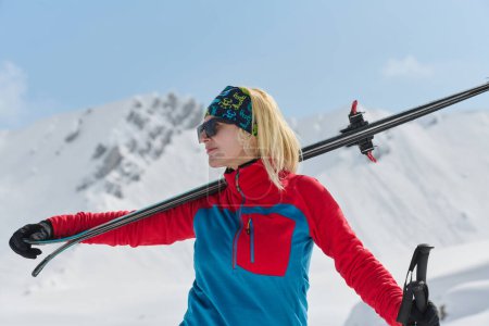 Foto de Una esquiadora profesional se regocija tras escalar con éxito los picos nevados de los Alpes. - Imagen libre de derechos