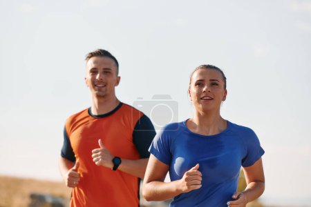 Foto de Una pareja vestida con ropa deportiva recorre un camino pintoresco durante un entrenamiento matutino, disfrutando del aire fresco y manteniendo un estilo de vida saludable.. - Imagen libre de derechos