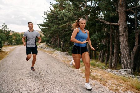 Ein Paar in Sportkleidung läuft während eines morgendlichen Workouts eine malerische Straße entlang, genießt die frische Luft und bewahrt einen gesunden Lebensstil.