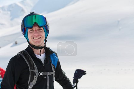 Téléchargez les photos : Un skieur professionnel savoure les vues à couper le souffle depuis les sommets enneigés des Alpes, se prélassant dans l'euphorie de leur ascension durement gagnée. - en image libre de droit