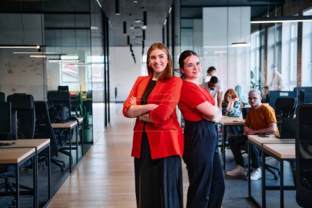 Eine Gruppe entschlossener Geschäftsfrauen posiert selbstbewusst Seite an Seite in einem modernen Start-up Coworking Center und verkörpert Professionalität und Empowerment. 