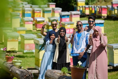 Foto de Un grupo diverso de jóvenes amigos y empresarios exploran pequeños negocios de producción de miel en el entorno natural del campo - Imagen libre de derechos