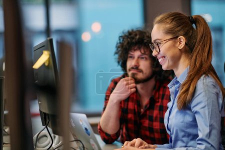 Photo for Business colleagues, a man and a woman, engage in discussing business strategies while attentively gazing at a computer monitor, epitomizing collaboration and innovation. - Royalty Free Image