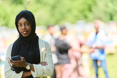 Téléchargez les photos : Femme musulmane du Moyen-Orient dans un hijab utilise un smartphone tout en gérant une petite entreprise apicole, mélangeant la technologie moderne avec les pratiques traditionnelles - en image libre de droit