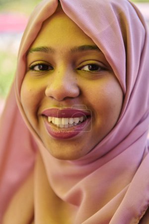 Photo for A Middle Eastern girl wearing a hijab, with a bright smile and a pink headscarf, captured in a close-up portrait exuding joy and positivity. - Royalty Free Image