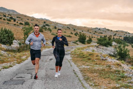 Photo for Couple conquer challenging mountain trails during an invigorating morning run. - Royalty Free Image