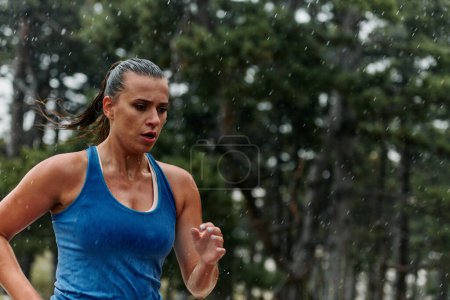 Foto de Lluvia o brillo, una maratonista dedicada a través de su carrera de entrenamiento, sus ojos puestos en la línea de meta. - Imagen libre de derechos
