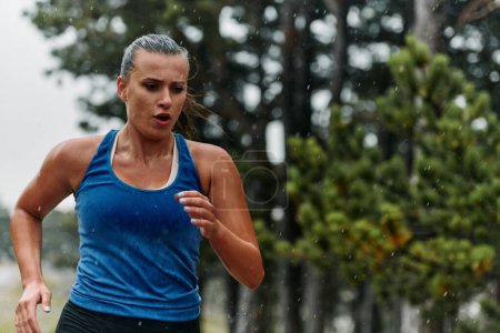 Téléchargez les photos : Pluie ou brillance, une marathonienne dévouée à travers sa course d'entraînement, les yeux fixés sur la ligne d'arrivée. - en image libre de droit