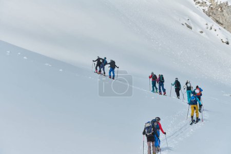 Eine Gruppe professioneller Skitourengeher besteigt mit modernster Ausrüstung einen gefährlichen schneebedeckten Gipfel. 