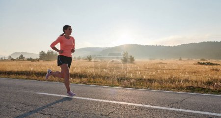 Téléchargez les photos : Une athlète résolue et motivée qui court avec confiance jusqu'au lever du soleil, incarnant la détermination et l'autonomisation dans sa course matinale. - en image libre de droit