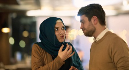  Islamic European couple shares laughter and enjoyment while savoring delicious pastries during iftar in the holy month of Ramadan, epitomizing joy, cultural celebration, and culinary delight. 
