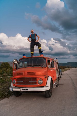 The firefighter standing confidently on the fire truck, ready to respond to any emergency. High quality photo