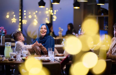 In einem modernen Restaurant warten ein islamisches Paar und ihre Kinder freudig auf ihr Iftar-Essen während des heiligen Monats Ramadan, das inmitten der heiligen Stätten familiäre Harmonie und kulturelles Feiern verkörpert.