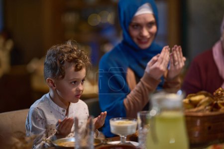 In a modern restaurant setting, a European Islamic family comes together for iftar during Ramadan, engaging in prayer before the meal, uniting tradition and contemporary practices in a celebration of