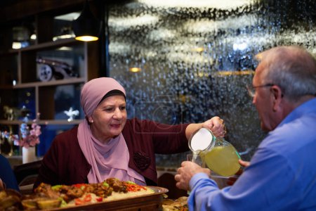 In a modern restaurant setting, an elderly Islamic European couple shares a meal for iftar during the holy month of Ramadan, epitomizing unity, companionship, and cultural tradition in their dining