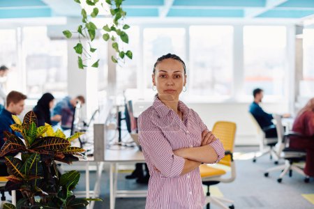 Porträt einer jungen lächelnden Geschäftsfrau im kreativen Coworking-Startup-Büro. Erfolgreiche Geschäftsfrau, die mit Copyspace im Amt ist. Mitarbeiter arbeiten im Hintergrund. 