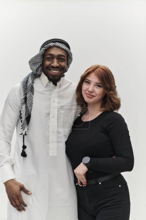 Empresario musulmán y una chica pelirroja contemporánea posan juntos contra un fondo blanco limpio, que encarna la confianza, la diversidad y un espíritu empresarial dinámico en su