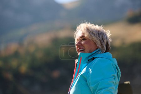 Eine Seniorin findet Gelassenheit und Wohlbefinden beim Spaziergang durch die Natur und veranschaulicht damit die Schönheit eines aktiven und gesundheitsbewussten Lebensstils in ihren goldenen Jahren..