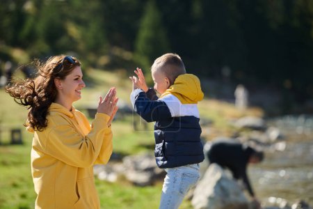 Una madre y un hijo crean recuerdos preciados mientras se dedican juguetonamente a actividades al aire libre, su risa se hace eco de la alegría de los momentos compartidos y el vínculo entre los padres y el niño.. 