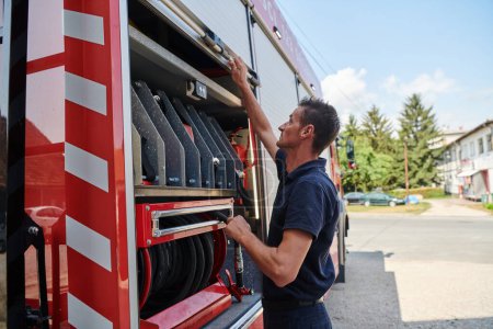 A dedicated firefighter preparing a modern firetruck for deployment to hazardous fire-stricken areas, demonstrating readiness and commitment to emergency response. 