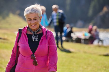 Eine Seniorin findet Gelassenheit und Wohlbefinden beim Spaziergang durch die Natur und veranschaulicht damit die Schönheit eines aktiven und gesundheitsbewussten Lebensstils in ihren goldenen Jahren..