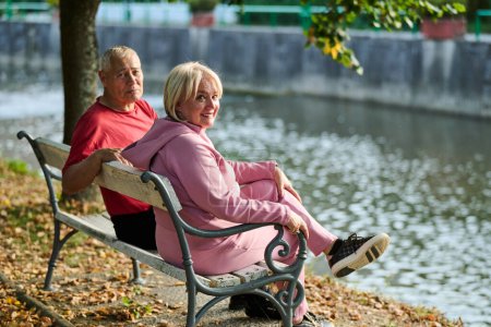 Photo for Elderly couple finding solace and joy as they rest on a park bench, engaged in heartfelt conversation, following a rejuvenating strol a testament to the enduring companionship and serene connection - Royalty Free Image