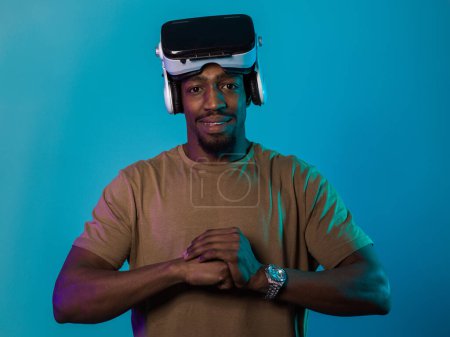 In an avant-garde scene, an African American man engages in cutting-edge virtual reality gaming, utilizing VR glasses to immerse himself in futuristic boxing games, set against a vivid blue background