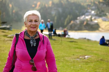 Une femme âgée trouve la sérénité et le bien-être en se promenant dans la nature, illustrant la beauté de maintenir un mode de vie actif et soucieux de la santé dans ses années d'or.