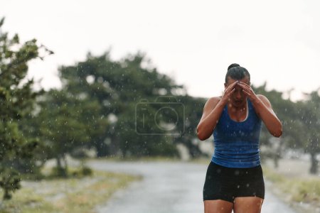 Ob Regen oder Sonnenschein, eine engagierte Frau fährt durch ihren Trainingslauf, die Augen auf die Ziellinie gerichtet. 