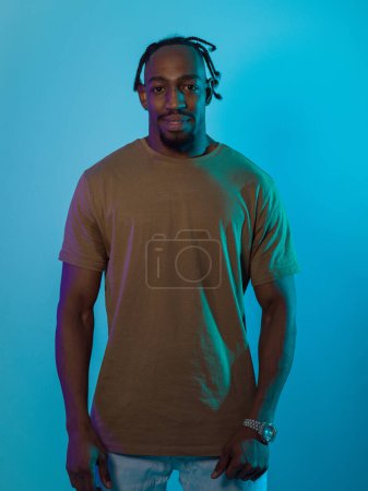 African American man with a modern and sophisticated hairstyle stands confidently against a vibrant blue backdrop, showcasing a blend of contemporary fashion and cultural identity with elegance and