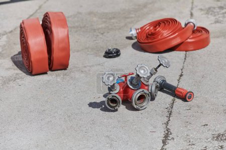 A neatly coiled fire hose lies on the ground, prepared and ready for immediate use in firefighting operations