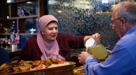 En un restaurante moderno, una pareja islámica europea de ancianos comparte una comida para iftar durante el mes sagrado del Ramadán, personificando la unidad, el compañerismo y la tradición cultural en su comedor.