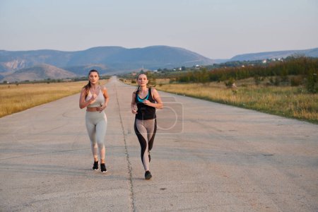 On a beautiful sunny day, two athletic friends enjoy a run together, maintaining their healthy lifestyle and fitness regimen.