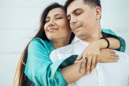 Photo for Young happy couple in love of different nationality hugging and kissing in the park.Asian woman and european man. Happy summer time. - Royalty Free Image