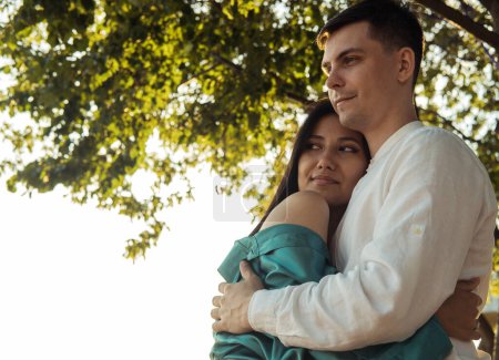 Foto de Joven pareja feliz enamorada de diferente nacionalidad abrazándose y besándose en el parque.Mujer asiática y hombre europeo. Feliz verano.. - Imagen libre de derechos