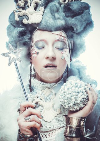 Photo for Party, christmas and people concept: Snow Queen, creative closeup portrait. Young woman in creative image with silver artistic make-up holding magic wand and christmas ball. - Royalty Free Image