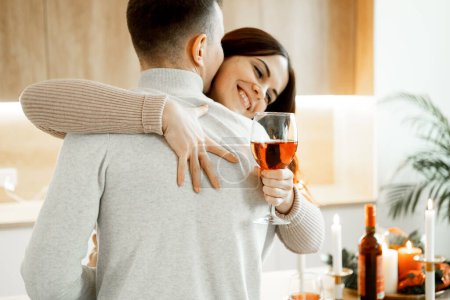 Photo for Young happyness couple in love drinking red wine in house kitchen - Royalty Free Image
