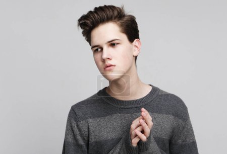 Foto de Modelo masculino joven con suéter. Retrato sobre fondo gris. De cerca.. - Imagen libre de derechos