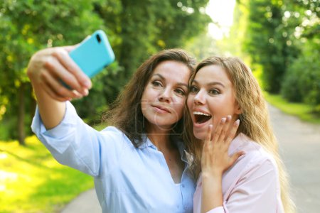 Photo for Happy senior woman and daughter taking selfie together, summer time - Royalty Free Image