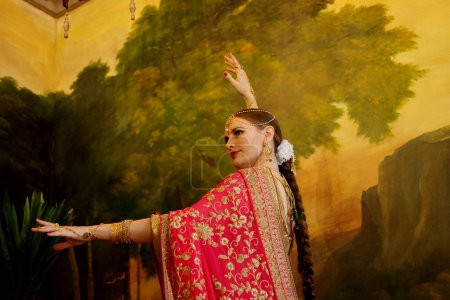 Foto de Hermosa mujer joven en vestido tradicional indio y joyas. Bailarina, traje de novia indio. Joyas ricas. - Imagen libre de derechos