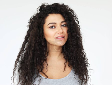 Foto de Young people, emotion and lifestyle concept: young smiling mulatto woman with long curly haor wearing casual shirt, feel happy and smiling, over white background - Imagen libre de derechos